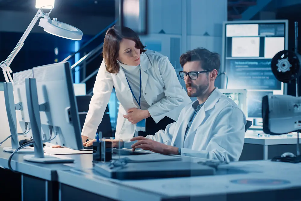 Innovation Partnerships: Man and women in a lab looking at a screen