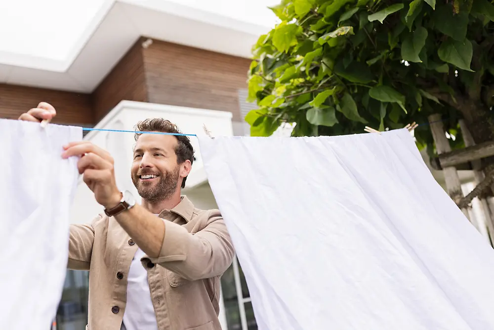 Person hanging up laundry under the sun to dry